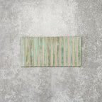 Product display of Pottery Decor Agave Green 12.5x25cm ceramic wall tiles in soft green tones, featuring a linear fluted design, handcrafted glossy finish and subtle tonal variation for textured contemporary interiors.