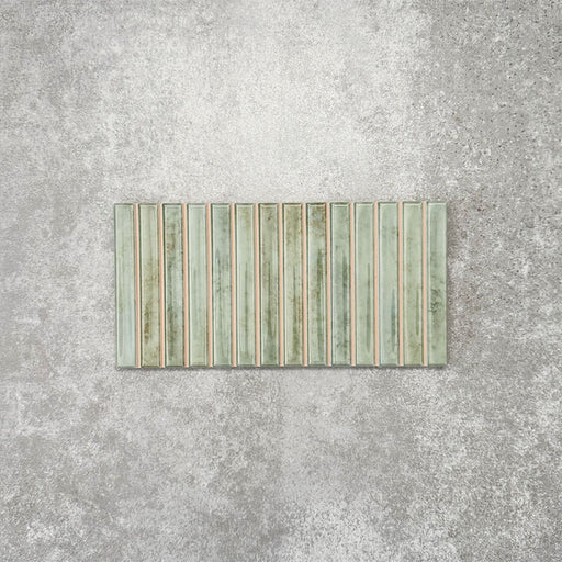 Product display of Pottery Decor Agave Green 12.5x25cm ceramic wall tiles in soft green tones, featuring a linear fluted design, handcrafted glossy finish and subtle tonal variation for textured contemporary interiors.