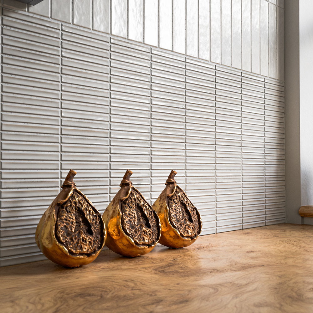 Kitchen splashback featuring Pottery Decor Blanco 12.5 × 25cm ceramic wall tiles, showcasing a textured linear relief design, soft white tones, and a subtle handcrafted finish, paired with warm wood surfaces and bronze decorative accents for a refined contemporary look.