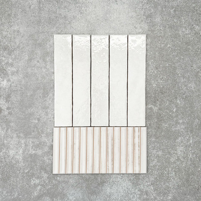 Product display of Pottery Decor Blanco 12.5x25cm ceramic wall tiles in soft white tones, featuring a handcrafted glossy finish with coordinating fluted decorative tiles for textured contemporary interiors.