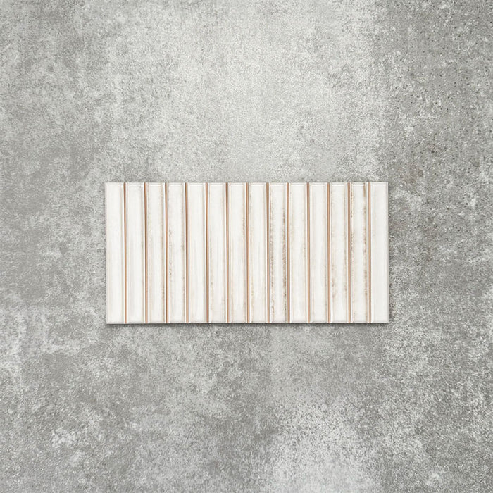 Product display of Pottery Decor Blanco 12.5x25cm ceramic wall tiles in soft white tones, featuring a linear fluted design, handcrafted glossy finish and subtle tonal variation for textured contemporary interiors.