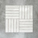 Product display of Pottery Brick Blanco 5x25cm glossy wall tiles in soft white tones, arranged in a basketweave layout with handcrafted edges and subtle surface variation against a textured concrete-style backdrop.