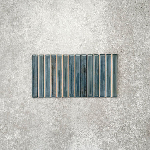 Product display of Pottery Decor Prussian 12.5x25cm ceramic wall tiles in deep blue tones, featuring a linear fluted design, handcrafted glossy finish and subtle tonal variation for textured contemporary interiors.