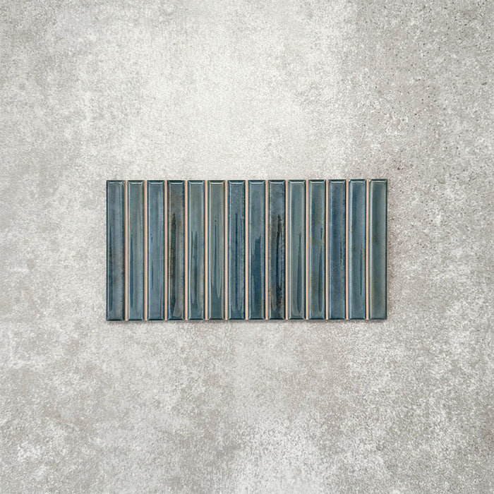 Product display of Pottery Decor Prussian 12.5x25cm ceramic wall tiles in deep blue tones, featuring a linear fluted design, handcrafted glossy finish and subtle tonal variation for textured contemporary interiors.