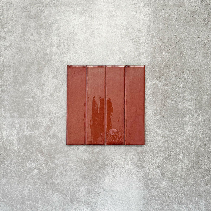 Product image of Puzzle Coral Brick Rectified 5x20cm wall and floor tiles, featuring a glossy coral finish with rich tonal variation and softly aged edges, displayed to highlight the tile's handcrafted character.