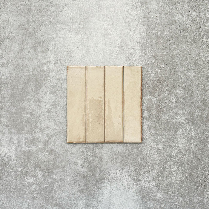 Product image of Puzzle Cream Brick Rectified 5x20cm wall and floor tiles, featuring a glossy cream finish with subtle shade variation and softly aged edges, displayed to highlight the tile's handcrafted character.