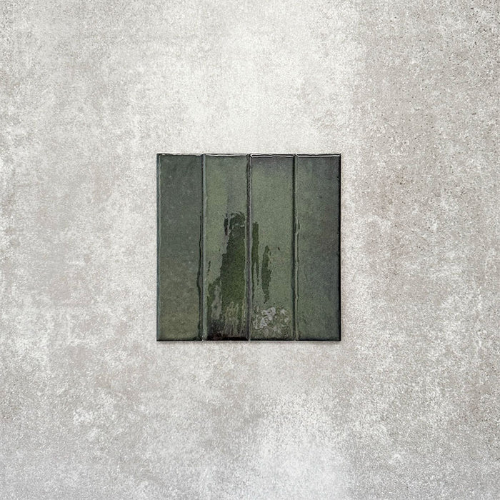 Product image of Puzzle Forest Green Brick Rectified 5x20cm wall and floor tiles, featuring a glossy deep green finish with rich tonal variation and softly aged edges, displayed to highlight the tile's handcrafted character.