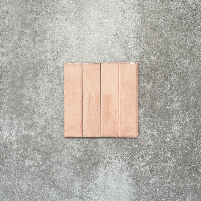 Product image of Puzzle Rose Brick Rectified 5x20cm wall and floor tiles, featuring a glossy blush pink finish with soft tonal variation and gently aged edges, displayed to highlight the tile's handcrafted character.