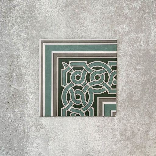 Single London Streets Regent Street Corner 20x20cm Victorian Moroccan style porcelain tile displayed in a product setting, featuring a decorative border corner design in green, sage and cream tones inspired by traditional Victorian entrance hall tile layouts.