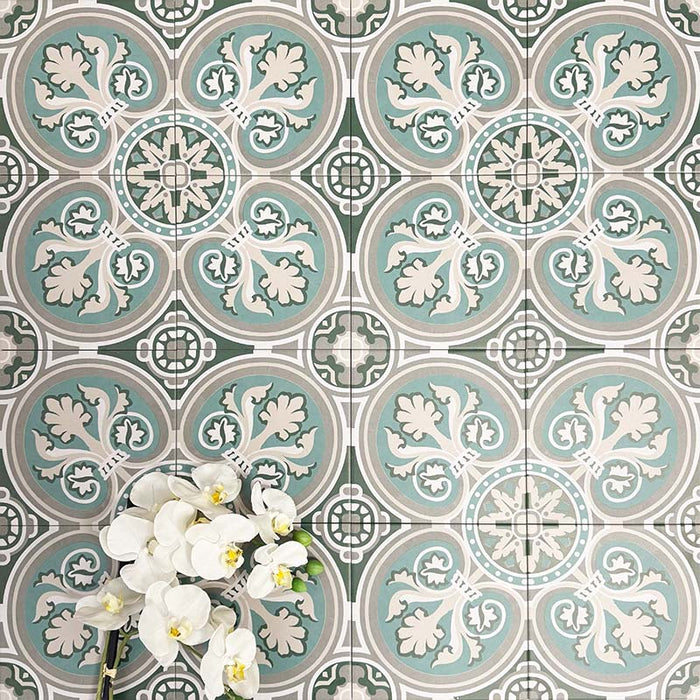 Group of London Streets Regent Street 20x20cm Victorian Moroccan style porcelain tiles arranged to showcase the repeating green, sage and cream floral geometric pattern, styled with white flowers in a decorative flat-lay setting.