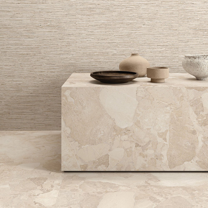 Interior featuring Riad Avorio Sassi Terrazzo Stone 60x60cm stone-effect wall and floor tiles, showcasing warm ivory and beige tones with natural stone-inspired detailing, styled with matching tiled cabinetry and light wood shelving for a contemporary finish.