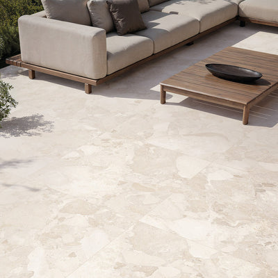 Contemporary outdoor patio featuring Riad Avorio Terrazzo 20mm 100x100cm outdoor stone-effect porcelain tile slabs, showcasing warm ivory and beige tones, paired with minimalist lounge seating, timber furniture and landscaped gardens.
