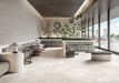 Contemporary lounge featuring Riad Blanco Sassi Terrazzo Stone 60x120cm stone-effect floor tiles, showcasing soft cream and beige tones with natural stone-inspired detailing, paired with minimalist seating, indoor planting and floor-to-ceiling glazing.