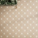 Close-up of Rubins Gold Decor MINI 15x15cm Moroccan-style porcelain floor tiles, featuring warm sandy beige tones and white eight-pointed star motifs in a repeating geometric pattern, paired with natural greenery and brass accents.