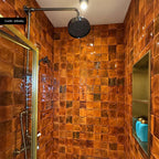 Customer shower featuring Saigon Amber Decor Square 10x10cm Moroccan-style wall tiles, with rich amber and burnt orange tones, a glossy textured finish and raised geometric detailing, paired with brass shower fittings.