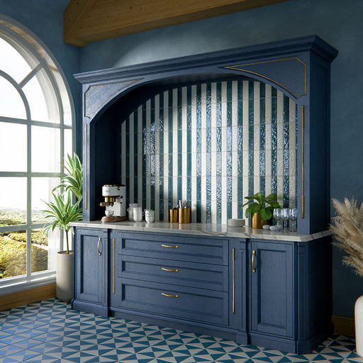Kitchen interior featuring Allegra Blue 6x25cm gloss brick tiles, installed vertically within a statement alcove, showcasing rich blue tones with a reflective glazed finish, styled with deep blue cabinetry, brass accents, and a marble-effect worktop for a bold yet elegant design.