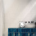 Bathroom interior featuring Foundry Bricks Arctic White 6.5x20cm ceramic wall tiles in a horizontal layout, styled with a blue tiled vanity, countertop basin and brushed metal fixtures.