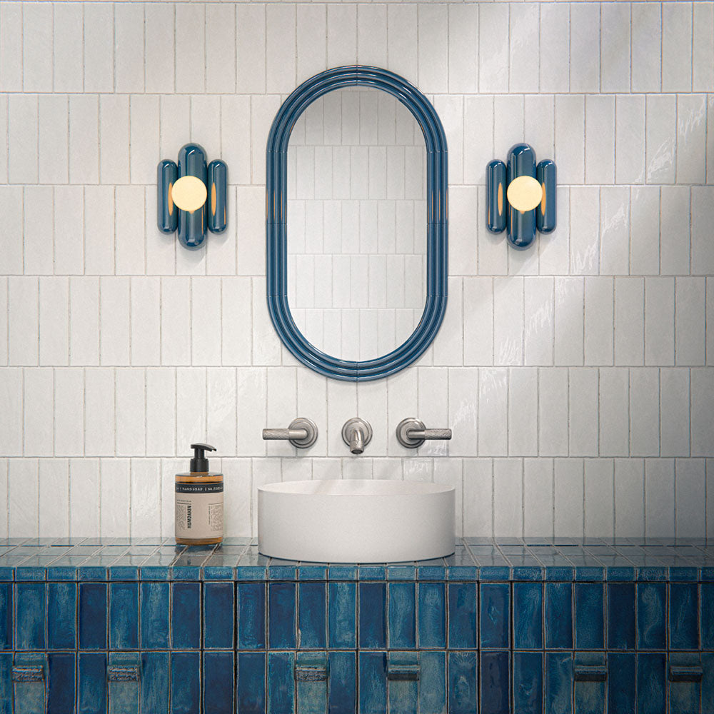 Bathroom interior featuring Foundry Bricks Arctic White 6.5x20cm ceramic wall tiles in a horizontal layout, styled with a blue tiled vanity, countertop basin and brushed metal fixtures.