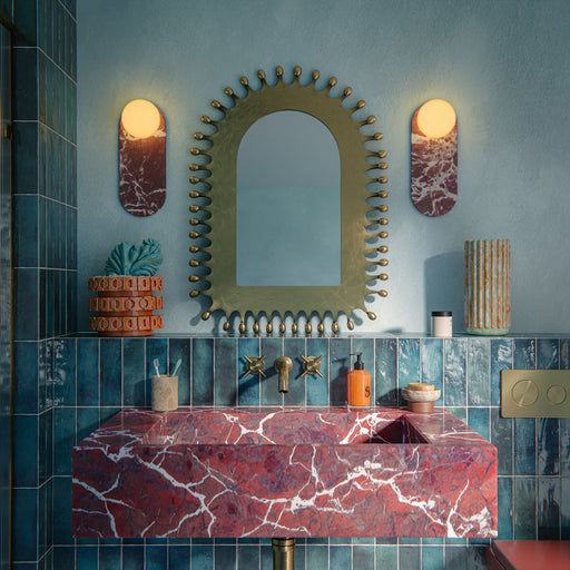 Bathroom setting featuring Foundry Bricks Marine Blue 6.5x20cm wall tiles, showcasing rich blue tones with subtle tonal variation, installed in a vertical layout across the walls, paired with terrazzo effect floor tiles, a statement red marble basin and brass fittings for a bold, design-led contrast.
