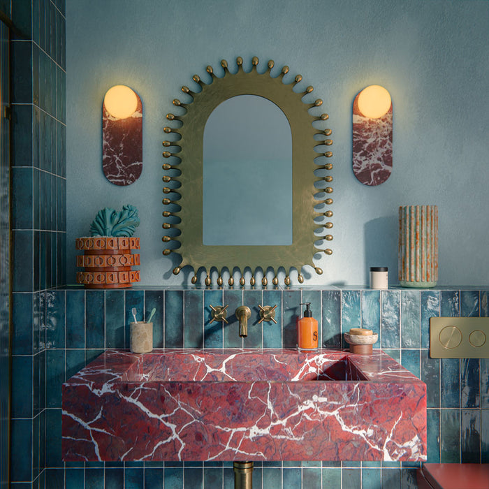 Bathroom setting featuring Foundry Bricks Marine Blue 6.5x20cm wall tiles, showcasing rich blue tones with subtle tonal variation, installed in a vertical layout across the walls, paired with terrazzo effect floor tiles, a statement red marble basin and brass fittings for a bold, design-led contrast.