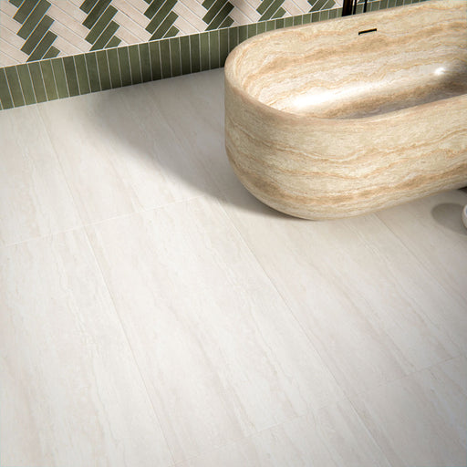 Bathroom interior featuring Trevi Stone 60 x 120cm porcelain floor tiles in a soft matt finish, showcasing a subtle natural stone effect in warm neutral tones, paired with a statement freestanding bath and patterned wall tiles to create a calm, balanced space.