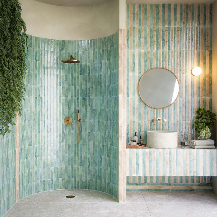 Bathroom setting featuring the Essentials Terrazzo Stone collection, showcasing neutral terrazzo effect floor tiles with soft tonal variation, paired with striped brick tiles and a stone basin for a calm, contemporary finish.
