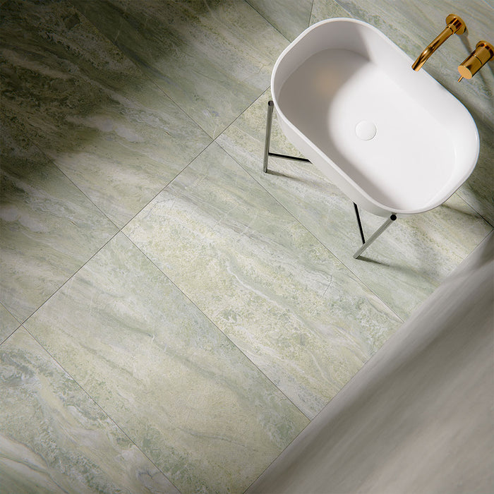 Bathroom interior featuring Petra Verde Green Stone marble style 60x120cm tiles, installed across walls and floor, showcasing soft green veining and natural stone-inspired movement, styled with brass fittings and modern basin.