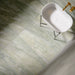 Bathroom interior featuring Petra Verde Green Stone marble style 60x120cm tiles, installed across walls and floor, showcasing soft green veining and natural stone-inspired movement, styled with brass fittings and modern basin.
