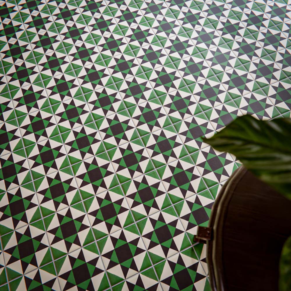 Close-up of Greenbrook Manor anti-slip encaustic Victorian-style porcelain tiles, showcasing a repeating geometric pattern of triangles in green, black and white across the floor.