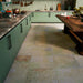Boho Ocean Blend 60x60cm patterned porcelain floor tiles styled in a contemporary green kitchen setting. The large-format design features a subtle, multi-tonal decorative pattern that blends soft sage, muted blue and warm neutral tones, adding gentle movement underfoot without overpowering the space. Paired with sage cabinetry, warm wood accents and brass details, the patterned floor creates a cohesive, design-led finish ideal for modern kitchen interiors.
