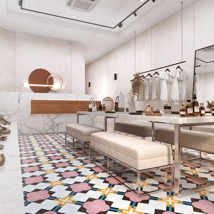 Retail interior featuring Abstract Contori Patterned Tiles in a 20x20cm format, laid as a decorative floor design. The elegant geometric pattern blends soft blush pink, muted green, mustard yellow and charcoal tones, paired with marble counters, neutral furnishings and contemporary lighting to create a refined, high-end boutique setting.