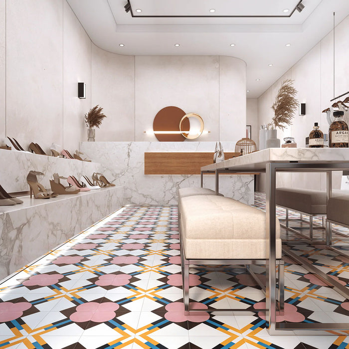 Retail interior featuring Abstract Contori Patterned Tiles in a 20x20cm format, laid as a decorative floor design. The elegant geometric pattern blends soft blush pink, muted green, mustard yellow and charcoal tones, paired with marble counters, neutral furnishings and contemporary lighting to create a refined, high-end boutique setting.
