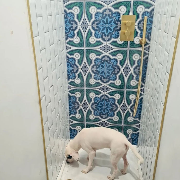 Shower interior featuring London Streets Baker Street 20x20cm Victorian Moroccan style wall tiles, styled with white metro wall tiles and brass shower fittings, creating a bold blue and green patterned shower feature wall.
