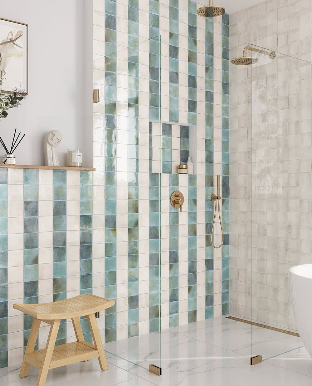 Bathroom interior featuring Saigon Celadon Green and Saigon White 10x10cm Moroccan-style square wall tiles installed in a vertical striped shower design, styled with brushed brass fittings, built-in niche, and a light, spa-inspired setting.