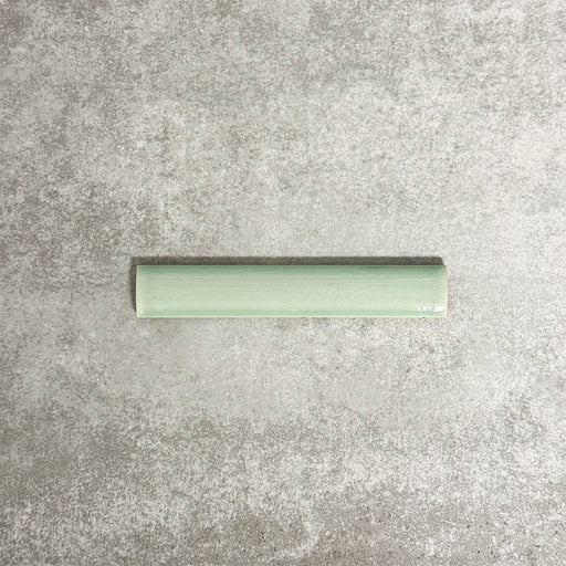 Pimlico Lime Green pencil trim tile measuring 2.5 × 15cm, featuring a crackle glaze finish and soft green tone, designed to neatly frame wall tiles and create a polished edge in bathrooms and kitchens.