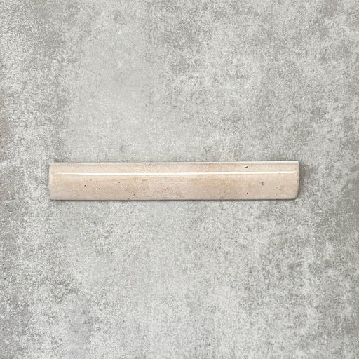 Nomad Oatmeal bullnose pencil border ceramic tile in a 3 × 20cm format, shown as a single piece highlighting the warm oatmeal colour, gloss finish and rounded profile.