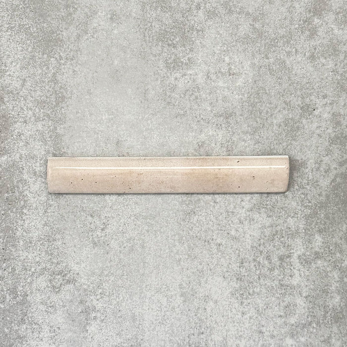 Nomad Oatmeal bullnose pencil border ceramic tile in a 3 × 20cm format, shown as a single piece highlighting the warm oatmeal colour, gloss finish and rounded profile.