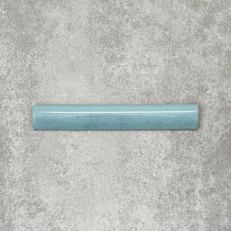 Nomad Aquamarine bullnose pencil border ceramic tile in a 3 × 20cm format, featuring a smooth rounded profile, glossy finish and soft blue-green tone, ideal for finishing edges and decorative wall details.