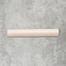Flat lay of Zellige Pink Mist Bullnose 3 × 20cm Moroccan-style ceramic trim tiles in soft pale pink tones, displayed with a smooth rounded edge and glossy glaze, arranged on a textured grey background to highlight the handcrafted zellige-effect finish and decorative edging profile.