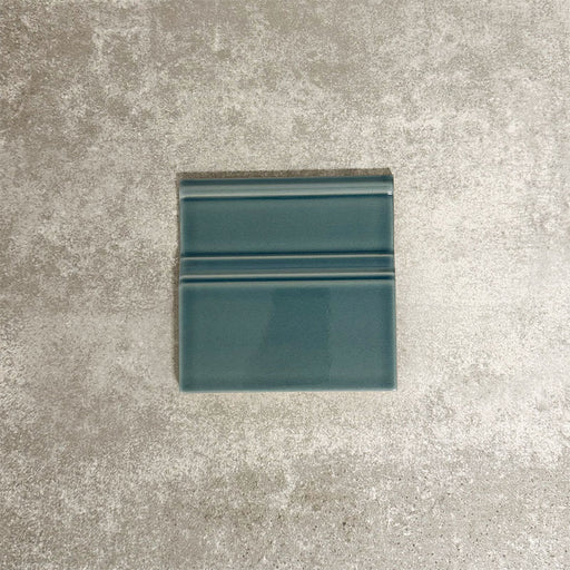 Pimlico River Blue 15 × 15cm ceramic skirting tile with a crackle glaze finish, featuring rich blue tones and moulded detailing, designed to create a neat transition between tiled walls and floors.