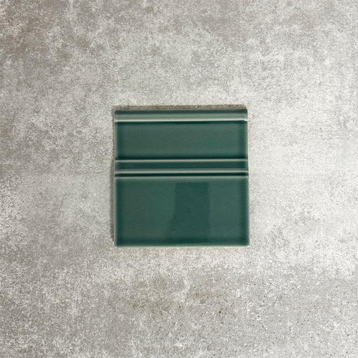 Pimlico Golders Green 15 × 15cm ceramic skirting tile with a crackle glaze finish, featuring rich green tones and moulded detailing, designed to create a neat transition between tiled walls and floors.