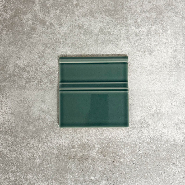 Pimlico Golders Green 15 × 15cm ceramic skirting tile with a crackle glaze finish, featuring rich green tones and moulded detailing, designed to create a neat transition between tiled walls and floors.