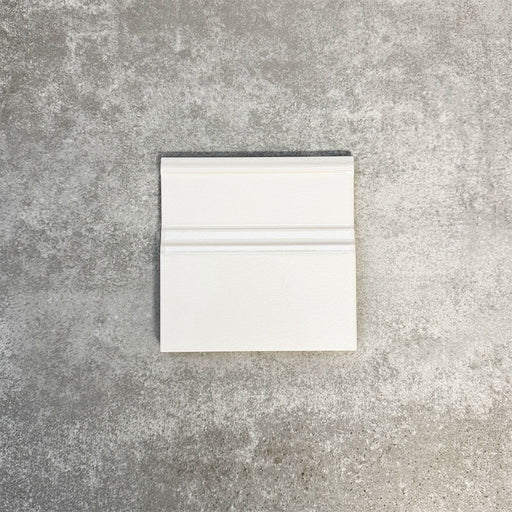 Pimlico White 15 × 15cm ceramic skirting tile with a crackle glaze finish, featuring soft white tones and moulded detailing, designed to create a neat transition between tiled walls and floors.