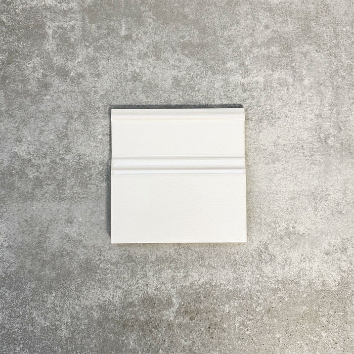 Pimlico White 15 × 15cm ceramic skirting tile with a crackle glaze finish, featuring soft white tones and moulded detailing, designed to create a neat transition between tiled walls and floors.