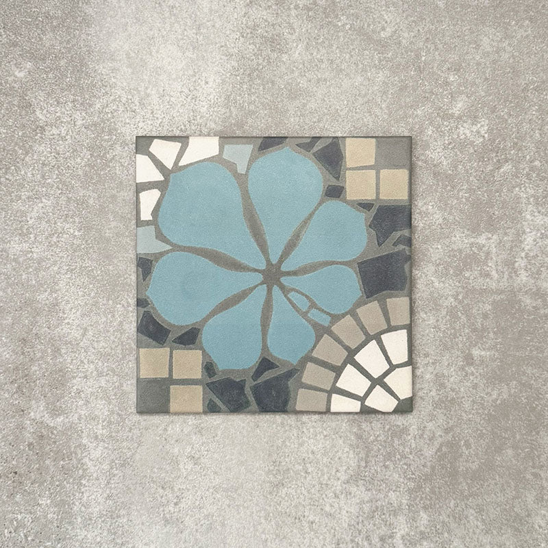 Nantes Azul Blue Moroccan-style tile in a 20x20cm format, shown as a single tile. The design features a soft blue floral motif set against mosaic-style detailing in muted greys, stone tones and white, highlighting the handcrafted, decorative character of this Moroccan-inspired patterned tile.