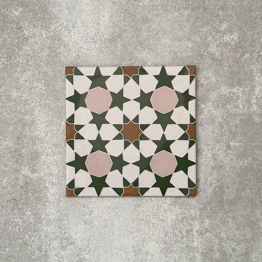 Cuba Tanane Moroccan-style porcelain tile in a 20×20cm square format, featuring a repeating geometric star pattern in deep green and white with soft pink accents and warm brown detailing, shown as a single tile on a neutral background.
