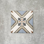Viscount Turner 20×20cm Victorian-style porcelain wall and floor tile featuring a geometric cross and floral-inspired motif in soft blue, white, grey and warm beige tones, photographed as a single tile on a neutral grey background.