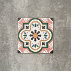 Single Cuba Paradise Moroccan-style porcelain tile in a 20×20cm square format, featuring a decorative floral motif in coral, green, white and brown tones, shown against a neutral background to highlight the tile’s intricate pattern and encaustic-style design.