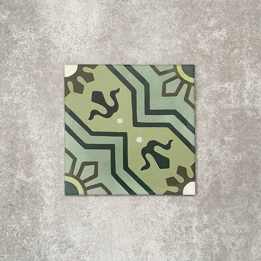 Single Balthazar Verde 20×20cm Moroccan-style porcelain tile displayed against a neutral stone-effect background, highlighting the intricate geometric pattern in layered green tones with contrasting dark accents and a traditional encaustic-inspired matt finish.