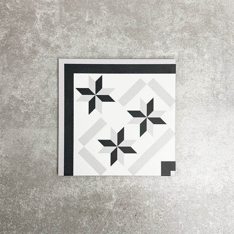 Single Canterbury Star Victorian-style porcelain corner tile in a 20 × 20cm format, featuring a coordinating star motif and contrasting black border detail, shown on a neutral background to highlight its use for creating neat, decorative corner finishes in patterned floor layouts.